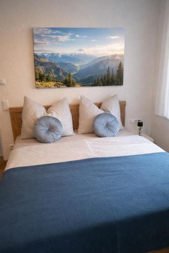 a bedroom with a large bed with blue pillows at der Untermühlbacher in Gnesau