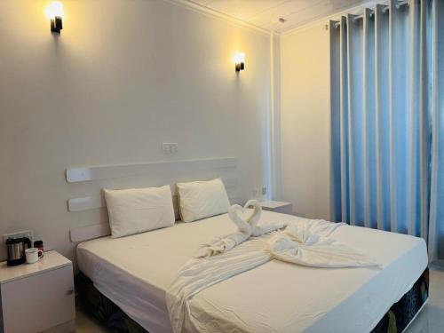 a bedroom with a bed with a swan decoration on it at Rihiveli Palace in Maamigili