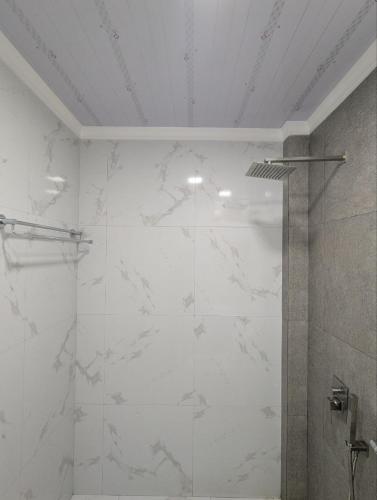a bathroom with a shower with white marble walls at Rihiveli Palace in Maamigili