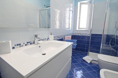 a bathroom with a white sink and a toilet at Appartamento Celestina Mare in Portoferraio