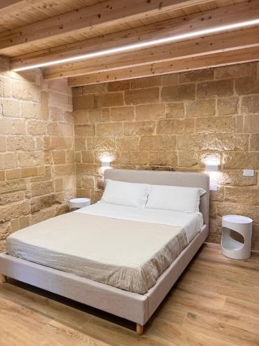 a bedroom with a bed in a brick wall at Petra dimora leccese in Lecce