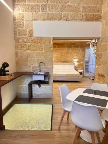 a room with a bed and a table and chairs at Petra dimora leccese in Lecce