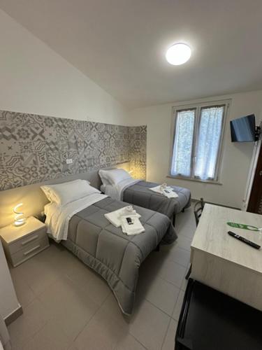 a hotel room with two beds and a table at Colle Muzia B&B e Affittacamere in Muccia