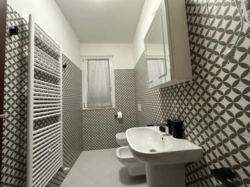 a bathroom with a sink and a toilet and a mirror at Colle Muzia B&B e Affittacamere in Muccia