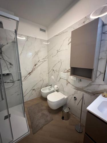 ein Badezimmer mit Toilette und einem Fernseher an der Wand in der Unterkunft Casa Delmo Comfort, eleganza e posizione strategica nel cuore della Valtellina in Sondrio