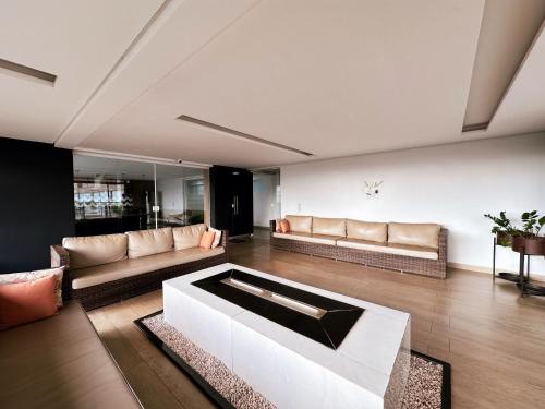 a living room with a couch and a table at Ribeirão Premium Apogeo in Ribeirão Preto