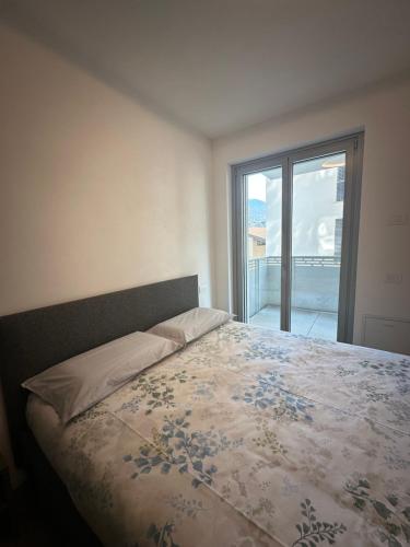 ein Schlafzimmer mit einem Bett und Blick auf einen Balkon in der Unterkunft Casa Delmo Comfort, eleganza e posizione strategica nel cuore della Valtellina in Sondrio