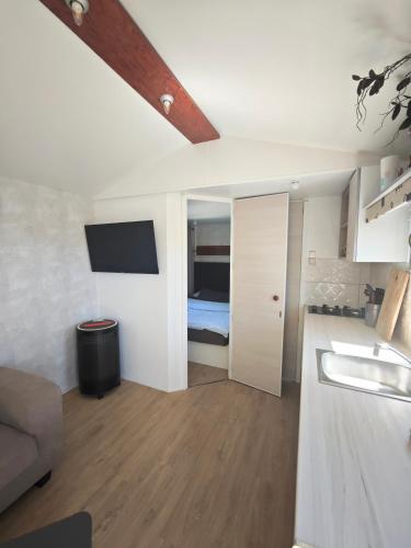 a kitchen with a sink and a bed in a room at Casa Azul-Tiny house with fantastic view, big outdoor space and pool in Silves