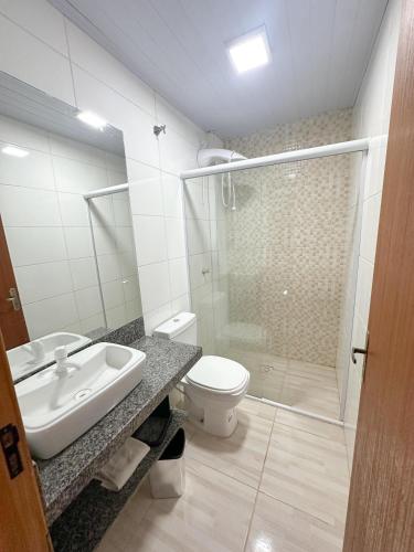 a bathroom with a toilet and a sink and a shower at Hotel 5km da Guarda do Embaú in Palhoça