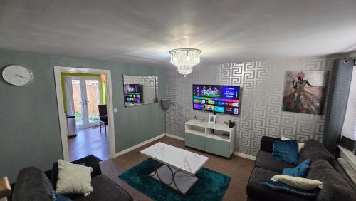 a living room with a couch and a tv at Well Furnished 3 Bedroom House in a cosy estate in Bolton in Bolton