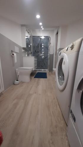 a bathroom with a washing machine and a toilet at Sotto i Lucernai in Cagli