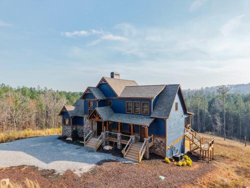 a large blue house on top of a field at Blue Salamander Lodge in Talking Rock