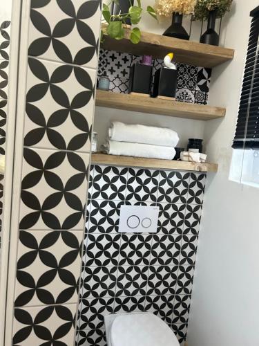 a bathroom with a black and white patterned wall at Private big Apartment in Eversdal