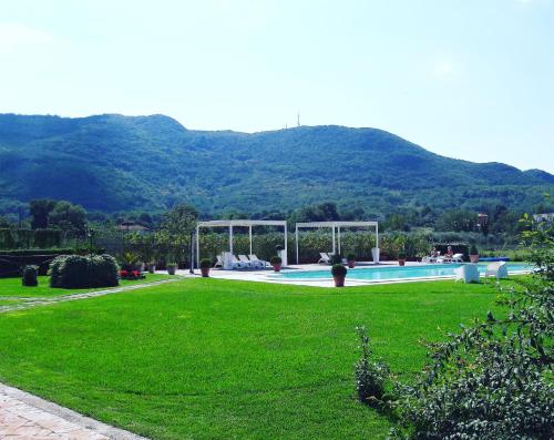 a swimming pool in a yard with a green lawn at Il Casale di Riardo Luxury B&B in Riardo