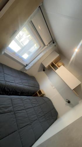 a loft bedroom with a bed and a window at Chez Gill & Clo in Saint-Julien-en-Born