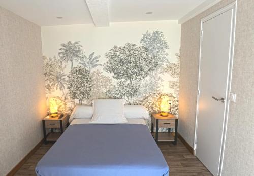 a bedroom with a bed and two lamps on tables at Le casse noisettes in Gourin
