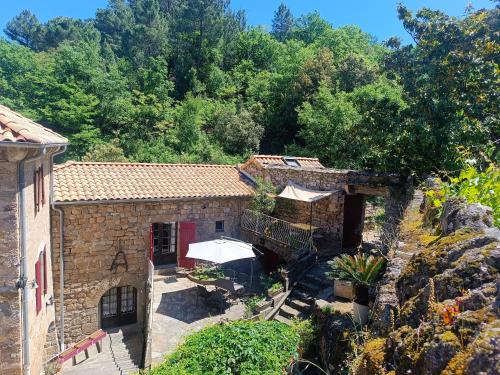 an old stone building with an umbrella in front of it at Aqua Terra Silva in Gravières