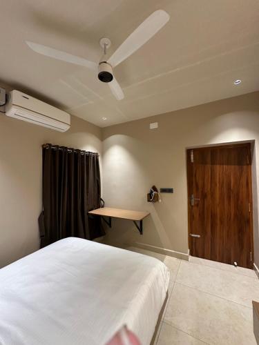 a bedroom with a bed and a wooden door at Vrs Homestay in Mayiladuthurai