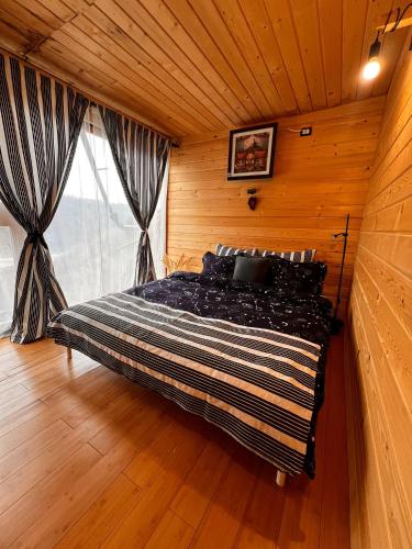 a bedroom with a large bed in a wooden room at Escaper at Nereju Star Place in Carşocheşti