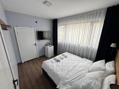 a bedroom with a white bed and a window at New Yasamkent Atakoru Double Suite in Alacaatlı