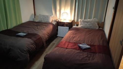 a hotel room with two beds and a window at 102個室元芸者の隠れ宿湯河原 in Yugawara