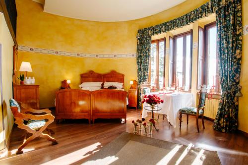 ein Schlafzimmer mit Bett, Tisch und Fenstern in der Unterkunft Al Borducan Boutique Hotel in Varese