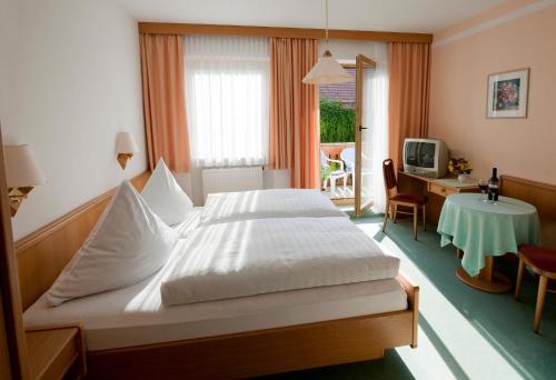 a bedroom with a bed and a desk and a television at Landhotel-Gasthof-Schreiner in Hohenau