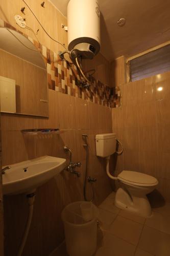 a bathroom with a toilet and a sink at Drizzle Drop Inn in Ooty