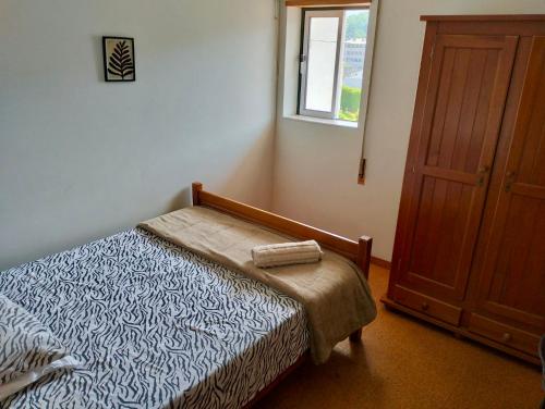 a small bedroom with a bed and a window at Casa Verde in Braga