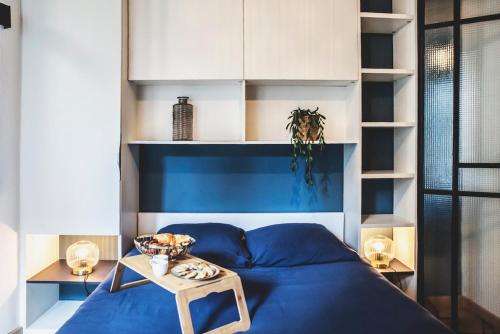 a bedroom with a blue bed and a table at Le charmant, Hyper Centre Angers in Angers