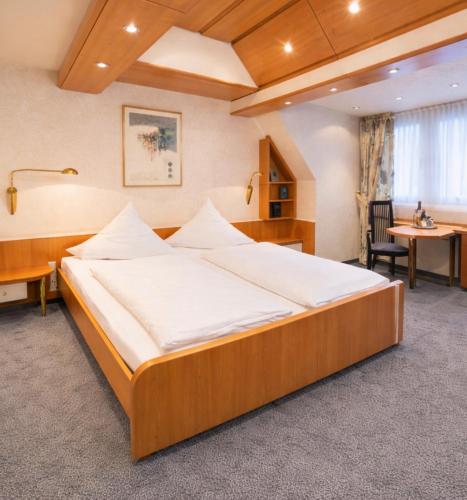 a bedroom with a large wooden bed in a room at Hotel ALMA in Wassenberg