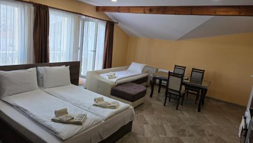 a bedroom with a bed and a couch and a table at MARIANA - Luxury stay private guest rooms in Gotse Delchev