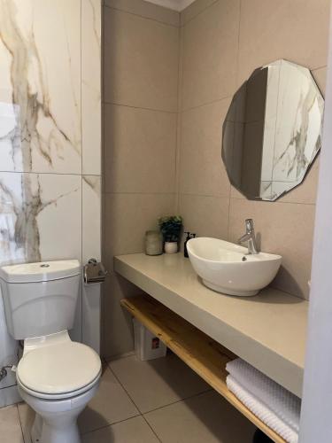a bathroom with a white toilet and a sink at Beachside Bliss Strand in Strand