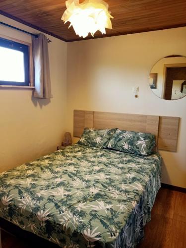 a bedroom with a bed with a green comforter at A l'Est d'Eden in Hastière-Lavaux