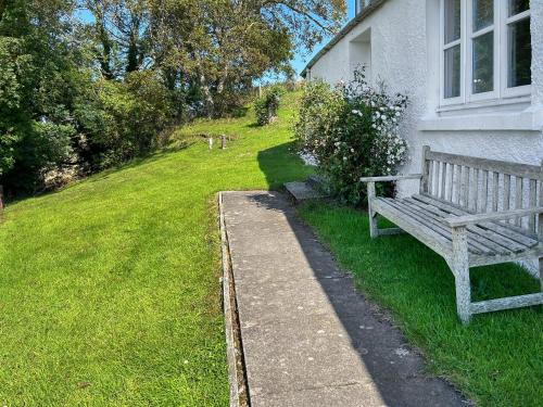 a wooden bench sitting in the grass next to a house at Rosscot in Ankerville