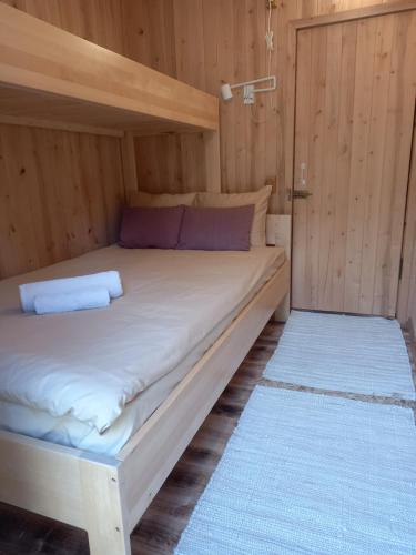 a large bed in a room with wooden walls at Vastseliina Metskond Camping in Vahtseliina