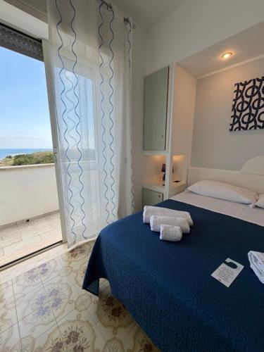 a bedroom with a bed and a large window at Hotel La Plancia in Otranto