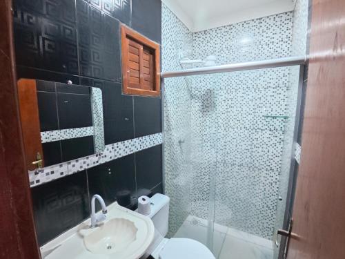 a bathroom with a shower and a sink and a toilet at Pousada pôr do sol in Riachuelo