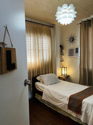 a bedroom with a bed and a chandelier at Anton and Isabel Bangued- 2BR for 5 in Bangued