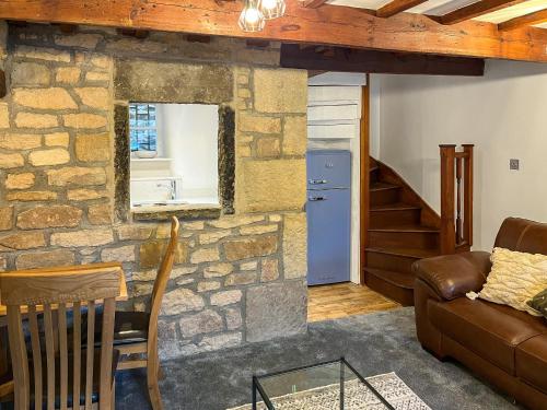 a living room with a stone wall at Candy Cottage in Addingham