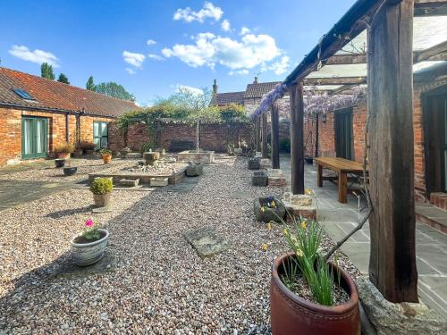 a garden with potted plants and a patio at Meadow View Broadlea in Stokeham