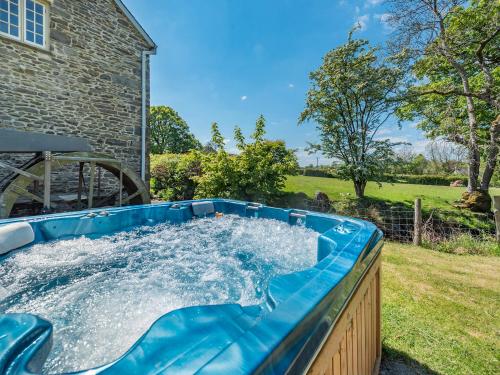 a hot tub in the backyard of a house at Dyffryn Glanffrwd Mill in Cellan