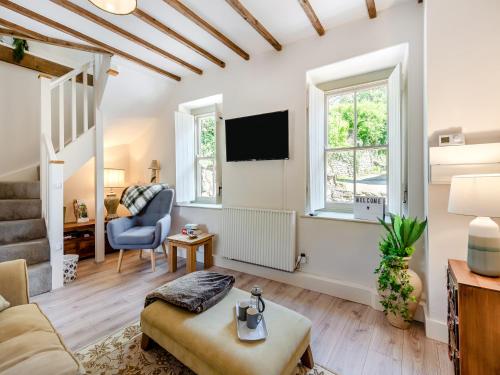 a living room with a couch and a tv at Dyffryn Glanffrwd Mill in Cellan