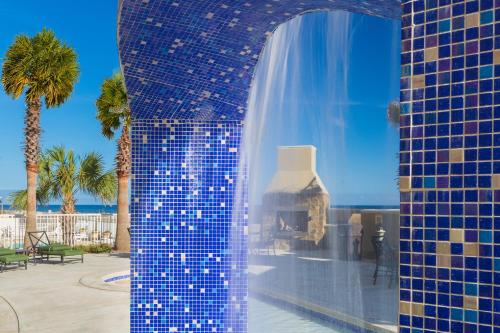 a blue tile wall with a fireplace in a resort at Escapes! To The Shores Orange Beach, A Ramada by Wyndham in Orange Beach