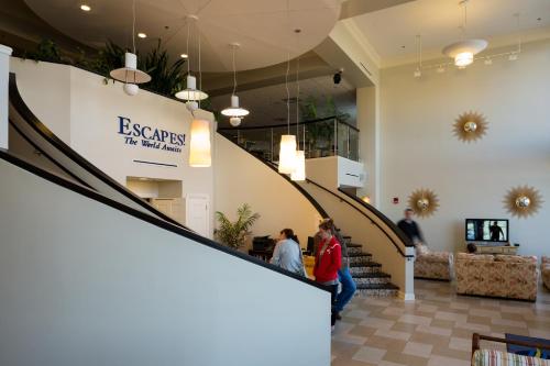a group of people walking down a staircase in a building at Escapes! To The Shores Orange Beach, A Ramada by Wyndham in Orange Beach