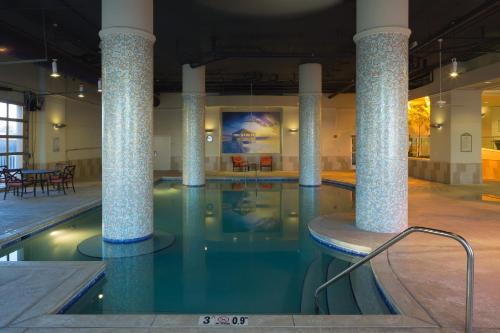 a swimming pool with columns in a building at Escapes! To The Shores Orange Beach, A Ramada by Wyndham in Orange Beach
