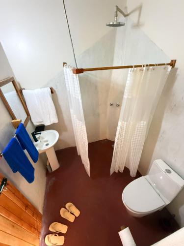 a bathroom with a toilet and a sink at Kibale Riverside Camp in Kamwenge
