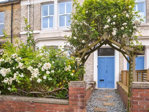 a blue door in front of a house with flowers at Longsands Retreat in Tynemouth