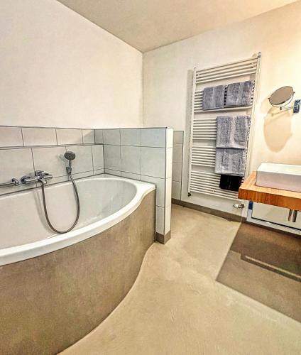 a bathroom with a bath tub and a window at Parkhotel Steimker Berg Wolfsburg in Wolfsburg