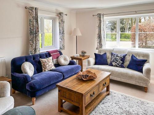 a living room with a blue couch and a table at Rosemeade in Hessett